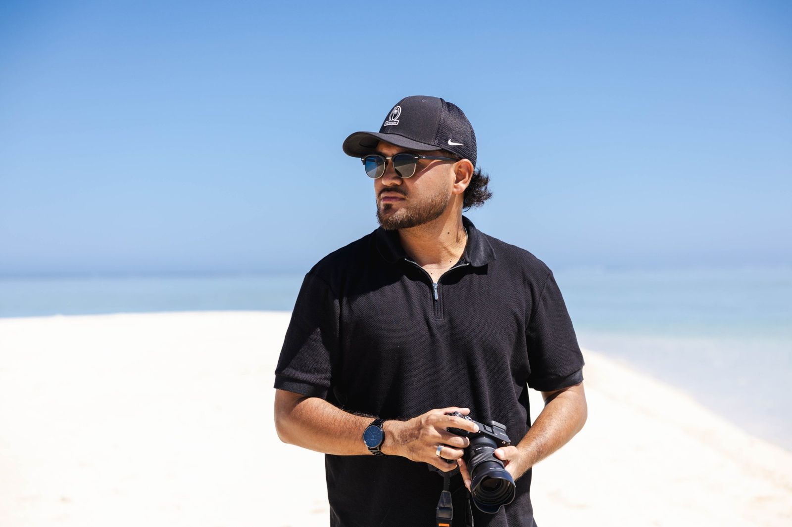 Soul Lens Fiji photographer holding a camera on a white sand beach