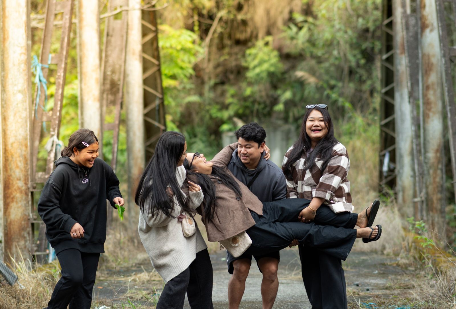 Family laughing as they lift their mother between them