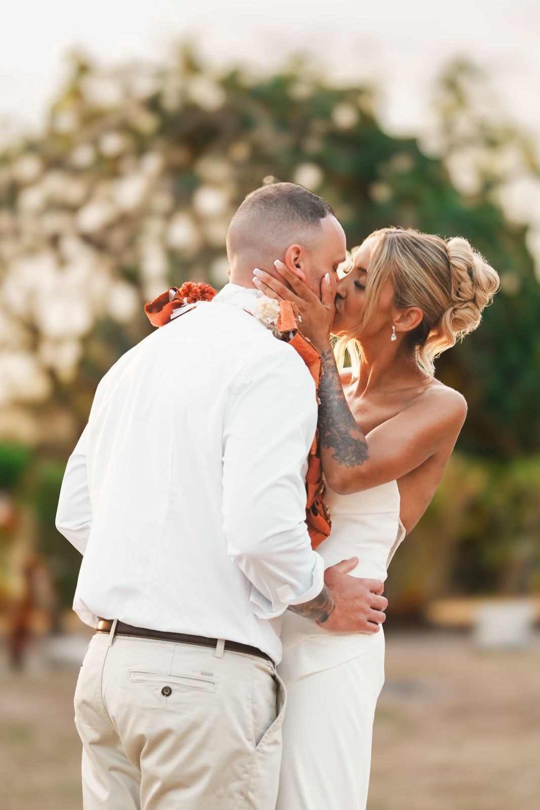 Bride and groom kissing at sunset